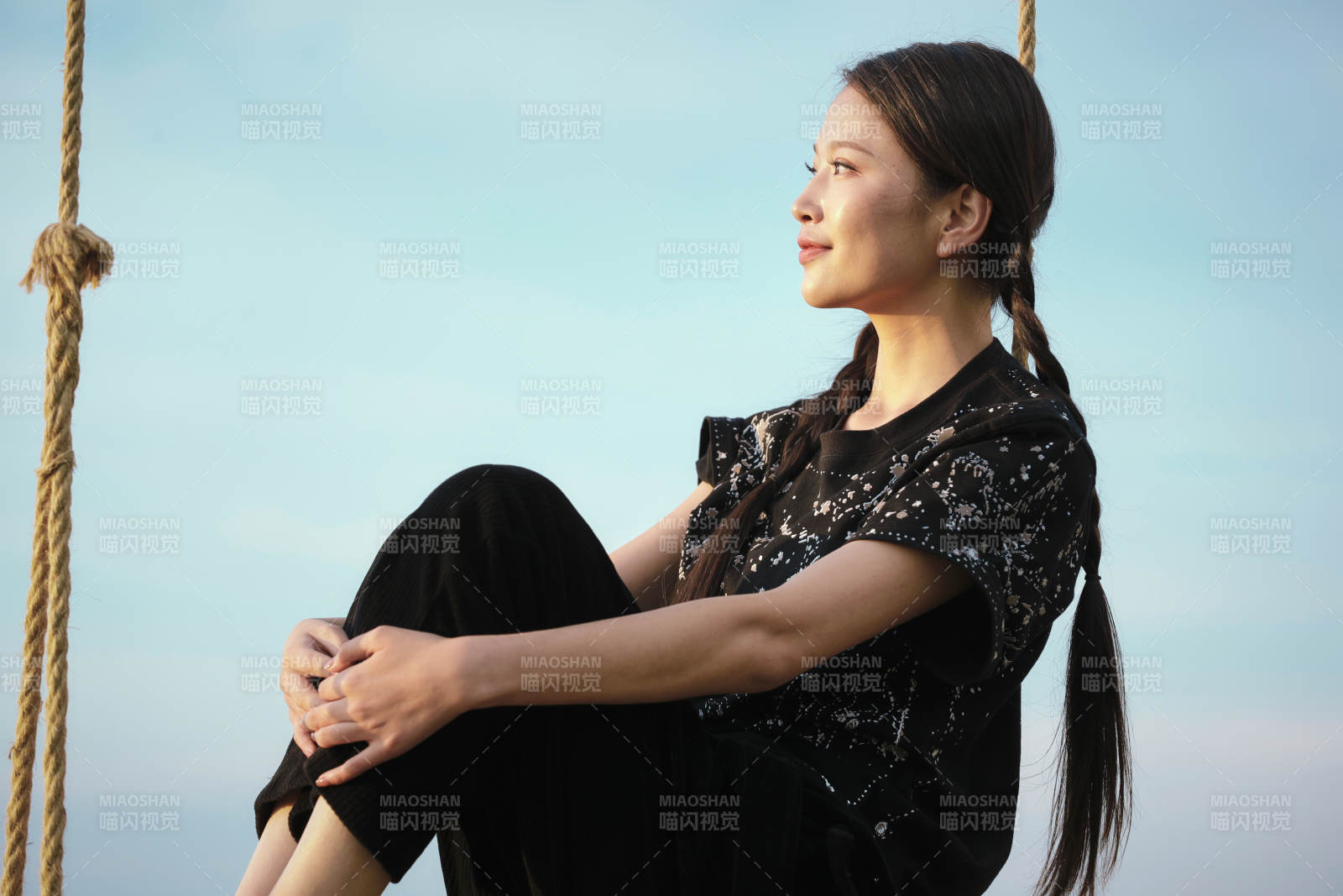 草原湖畔夕阳下荡秋千的亚洲少女图片