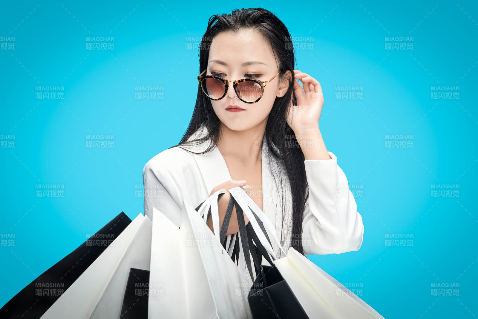 青蓝色背景下手提购物袋的亚洲时尚少女图片