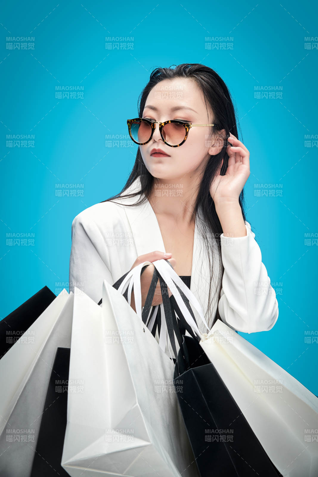 青蓝色背景下手提购物袋的亚洲时尚少女图片