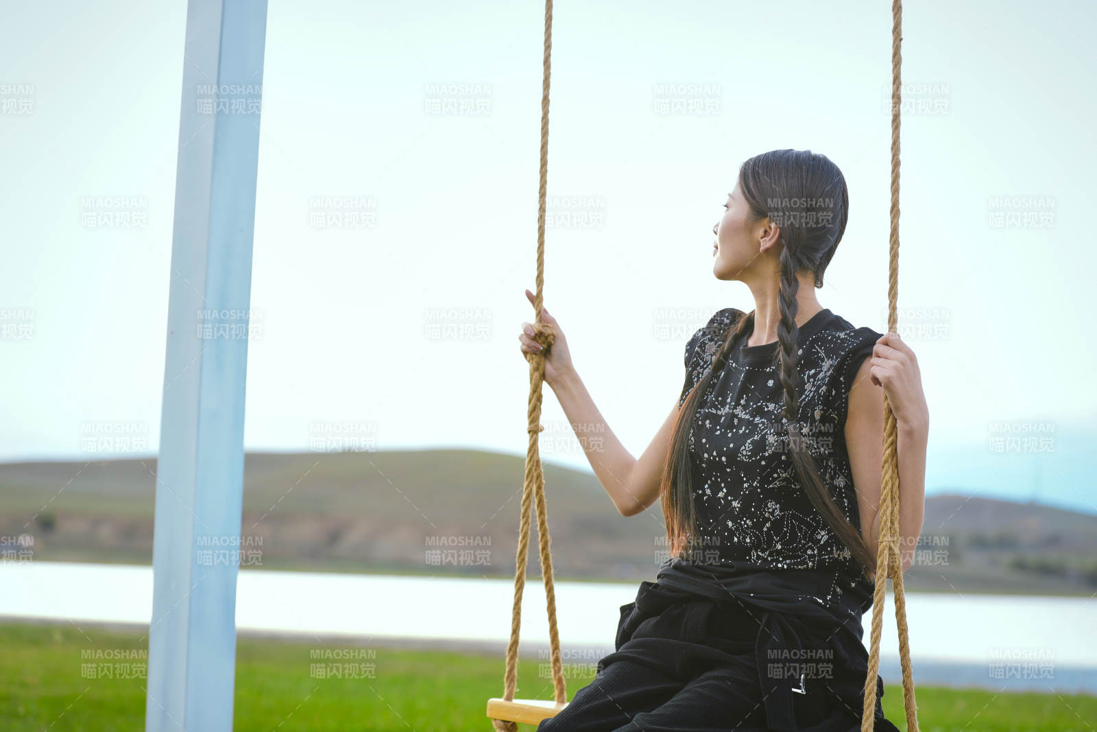 草原湖畔夕阳下荡秋千的亚洲少女图片