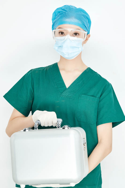 手持外科医疗手术器械箱的年轻女性医生图片