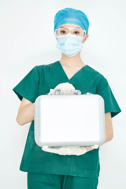 手持外科医疗手术器械箱的年轻女性医生图片