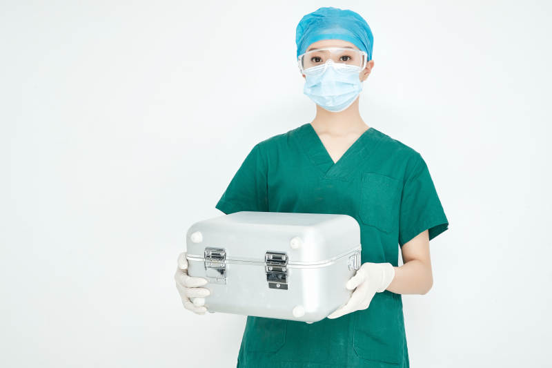 手持外科医疗手术器械箱的年轻女性医生图片