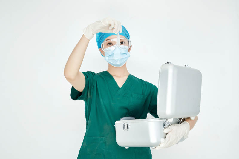 手持外科医疗手术器械箱的年轻女性医生图片