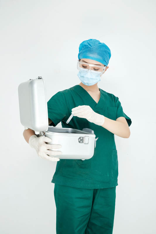 手持外科医疗手术器械箱的年轻女性医生图片