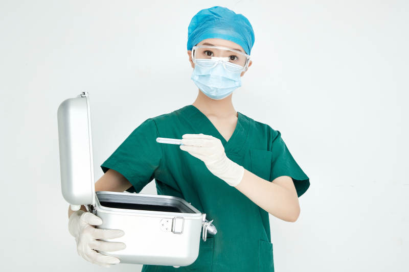 手持外科医疗手术器械箱的年轻女性医生图片