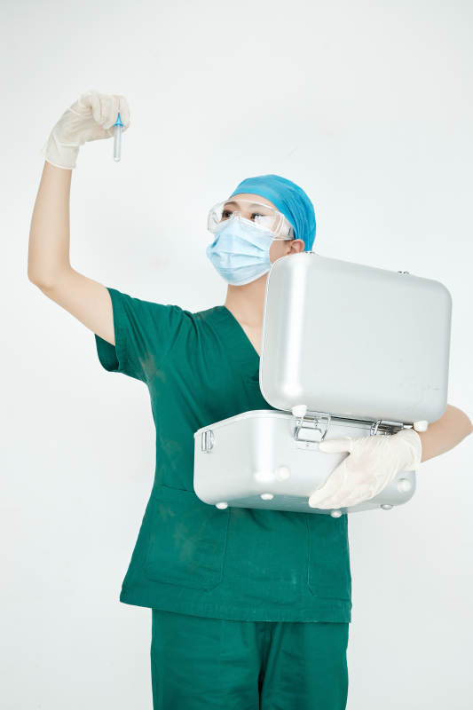 手持外科医疗手术器械箱的年轻女性医生图片