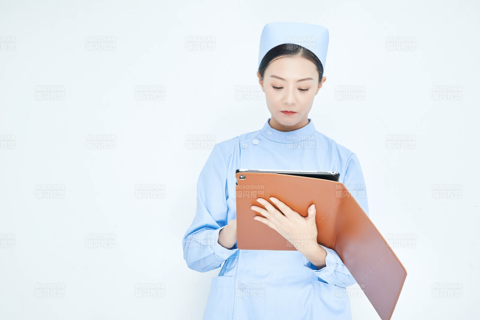身穿护士服手拿医用iPad的年轻护士图片
