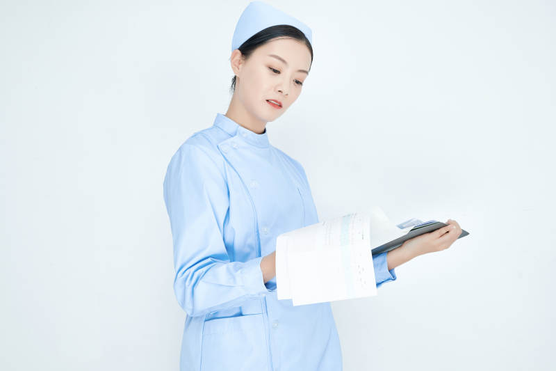 白背景里穿蓝色护士服手持病历夹的美女护士图片