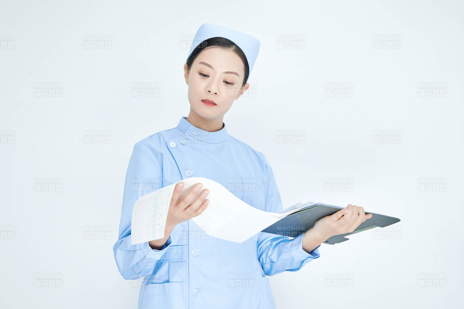 白背景里穿蓝色护士服手持病历夹的美女护士图片
