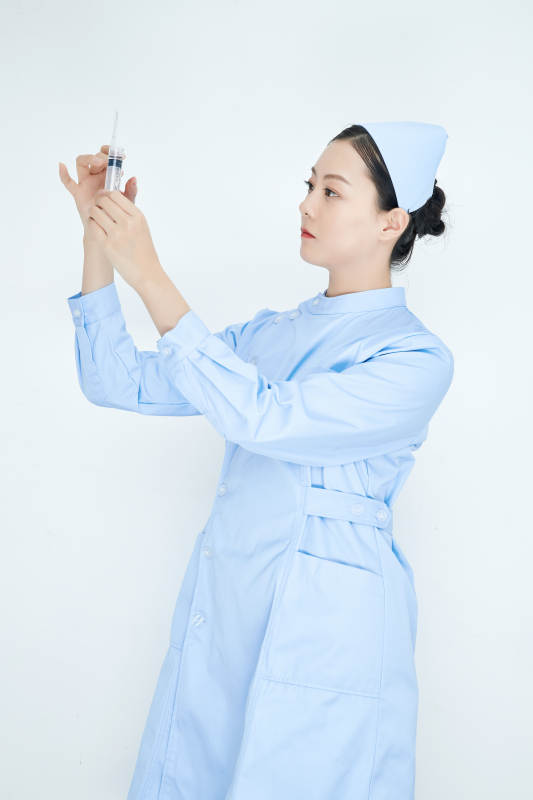 穿护士服戴口罩手执针筒的年轻女护士图片