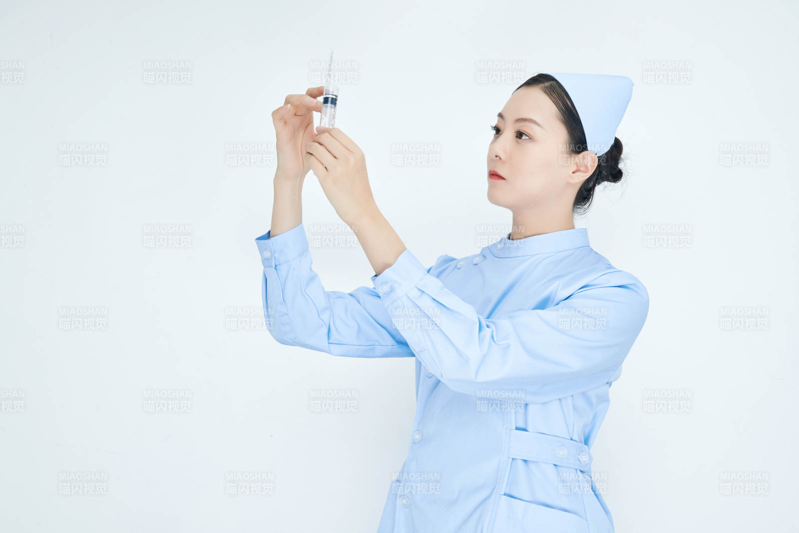 穿护士服戴口罩手执针筒的年轻女护士图片