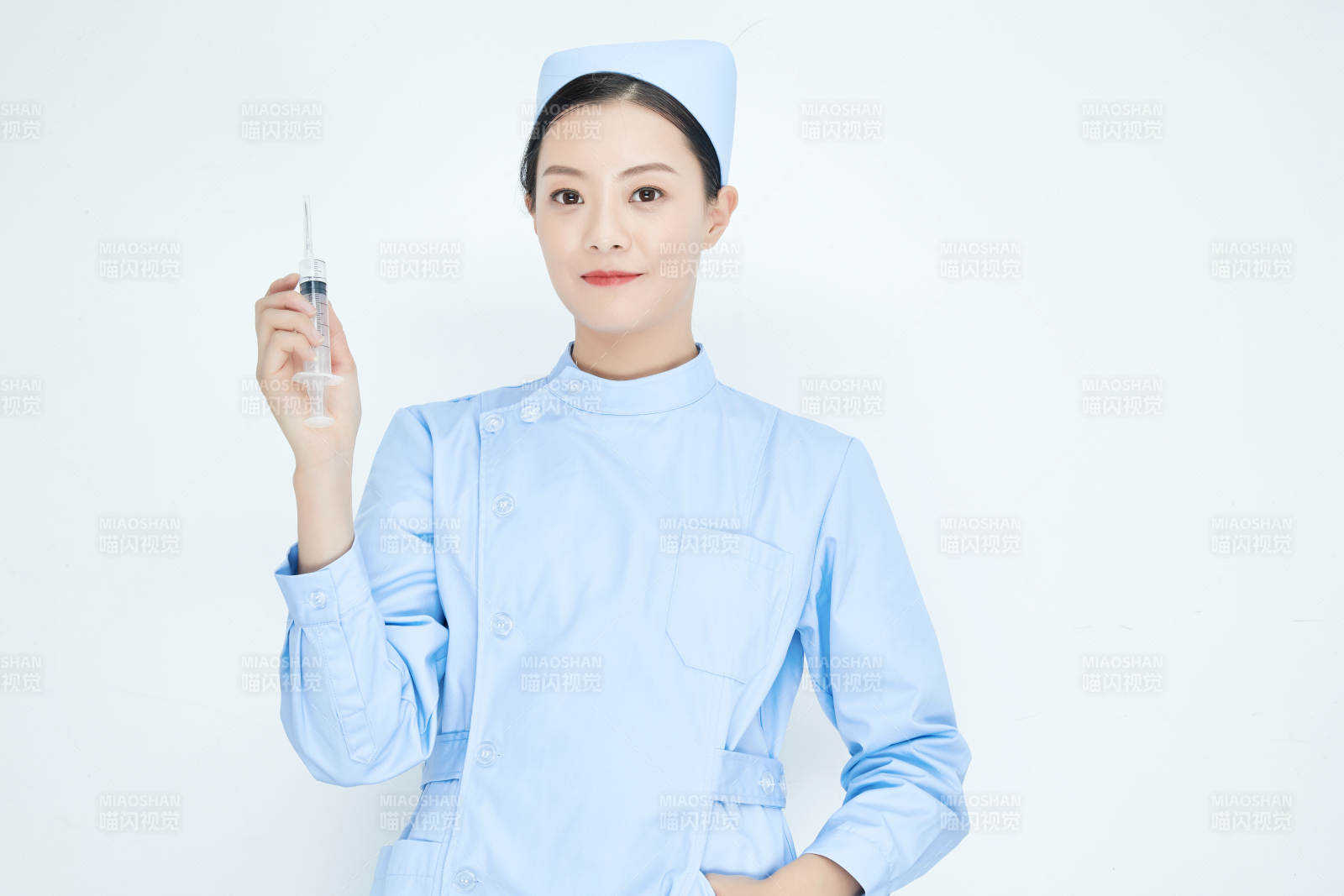 穿护士服戴口罩手执针筒的年轻女护士图片