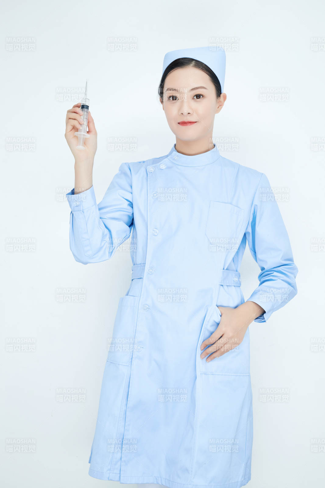 穿护士服戴口罩手执针筒的年轻女护士图片