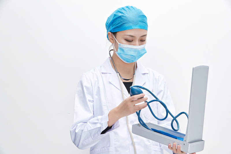 白色背景下手持血压计的门诊医生图片