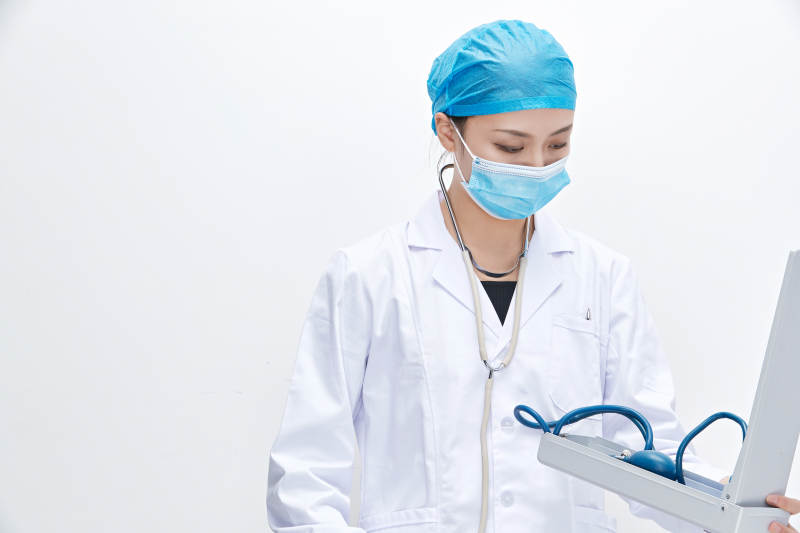 白色背景下手持血压计的门诊医生图片