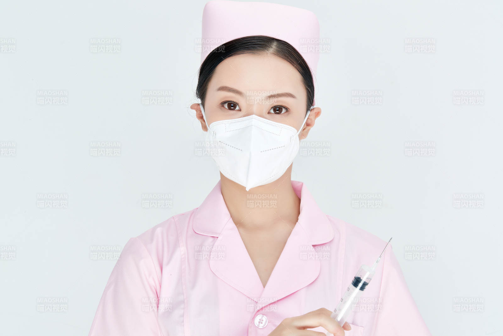穿护士服戴口罩手执针筒的年轻女护士图片