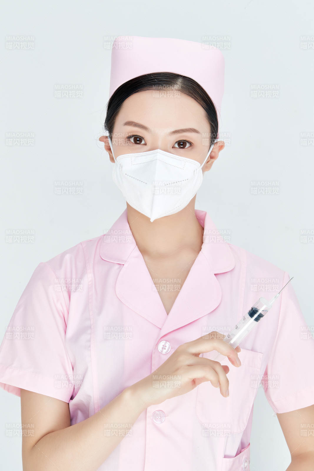 穿护士服戴口罩手执针筒的年轻女护士图片