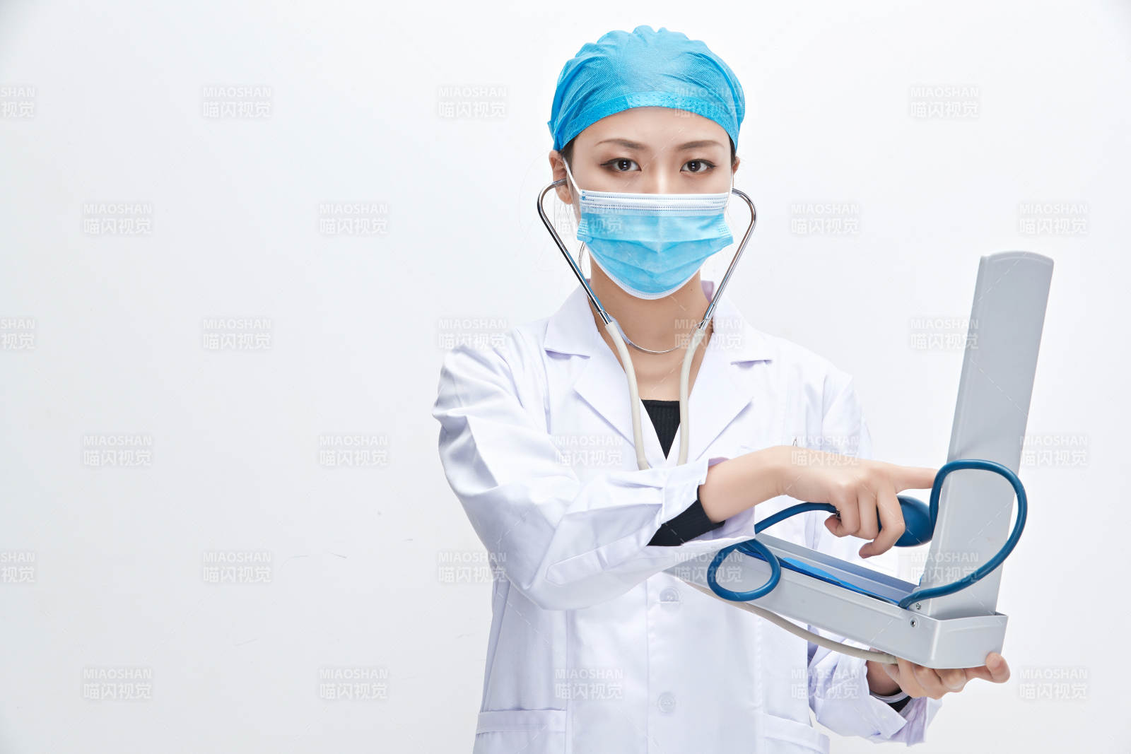 白色背景下手持血压计的门诊医生图片