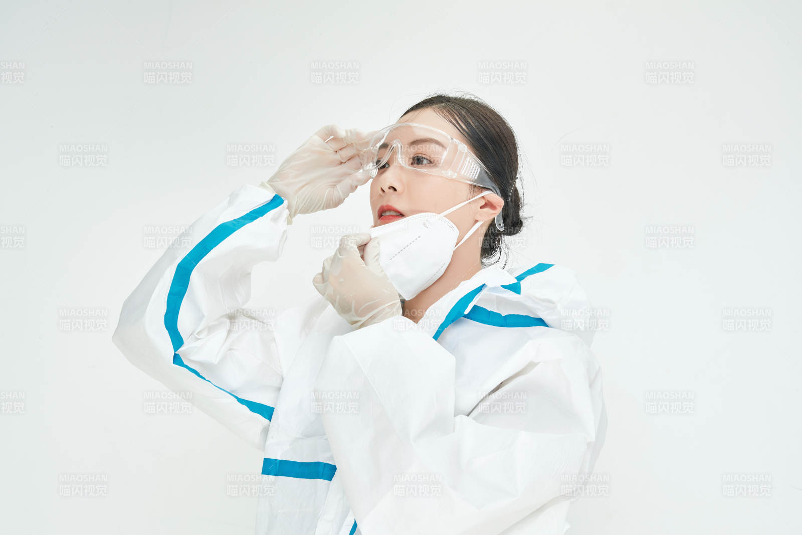 穿白色防护服佩戴护目镜口罩的女性医疗人员图片