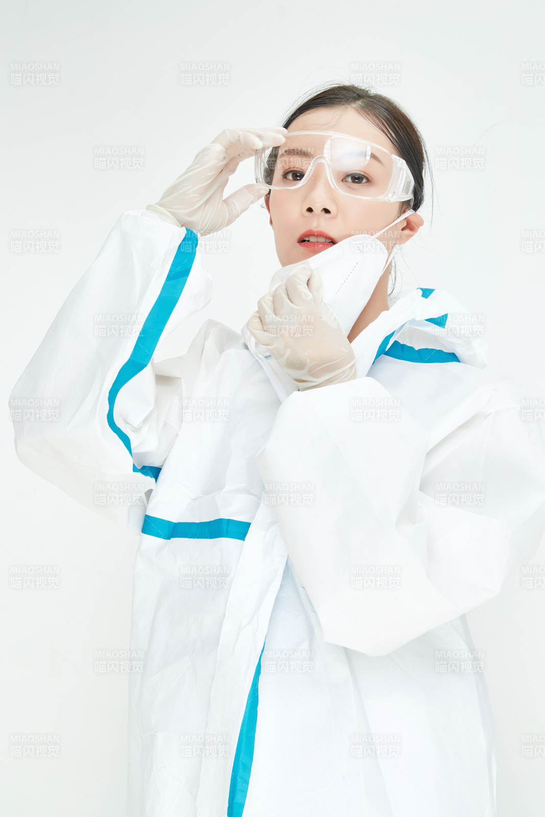 穿白色防护服佩戴护目镜口罩的女性医疗人员图片