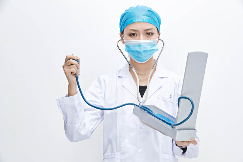 白色背景下手持血压计的门诊医生图片