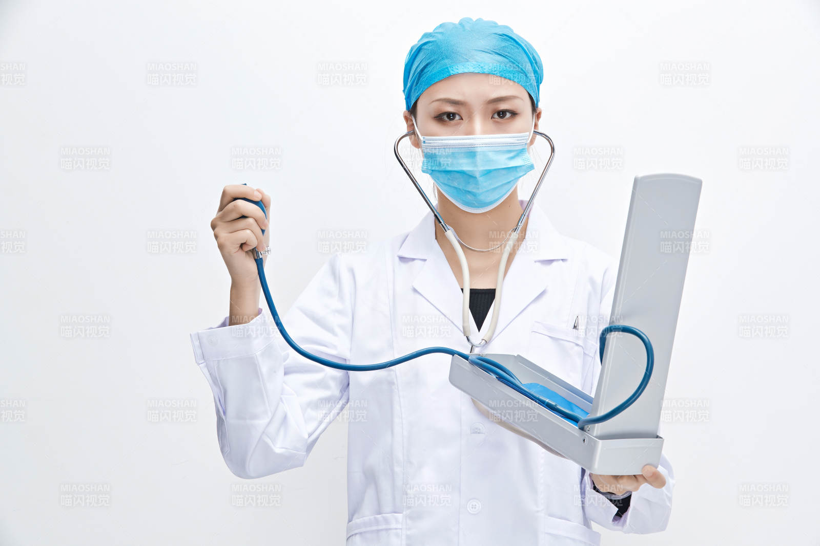 白色背景下手持血压计的门诊医生图片