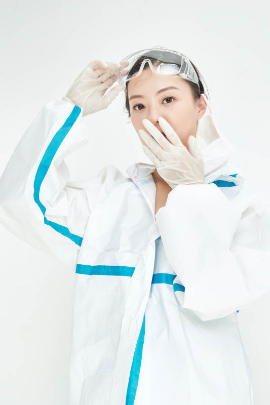 穿白色防护服佩戴护目镜口罩的女性医疗人员图片