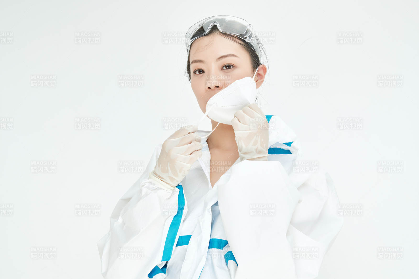 穿白色防护服佩戴护目镜口罩的女性医疗人员图片