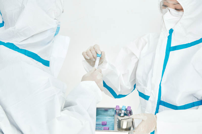 穿白色防护服佩戴护目镜口罩的女性医疗人员图片