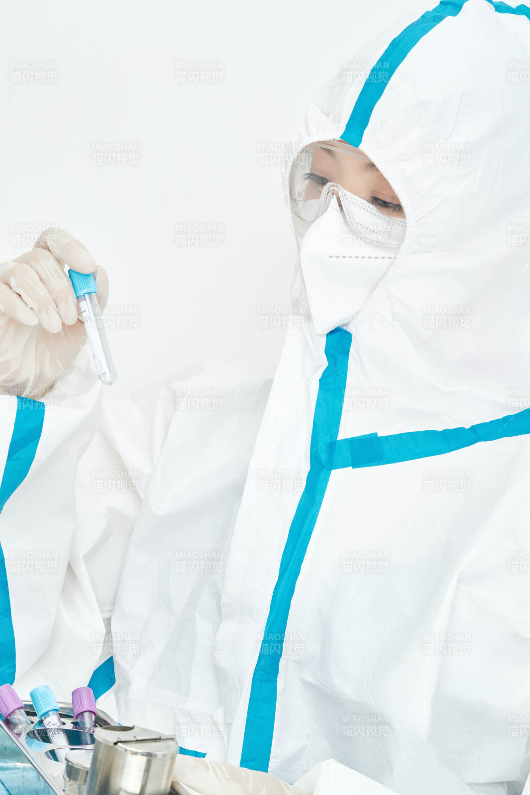 穿白色防护服佩戴护目镜口罩的女性医疗人员图片