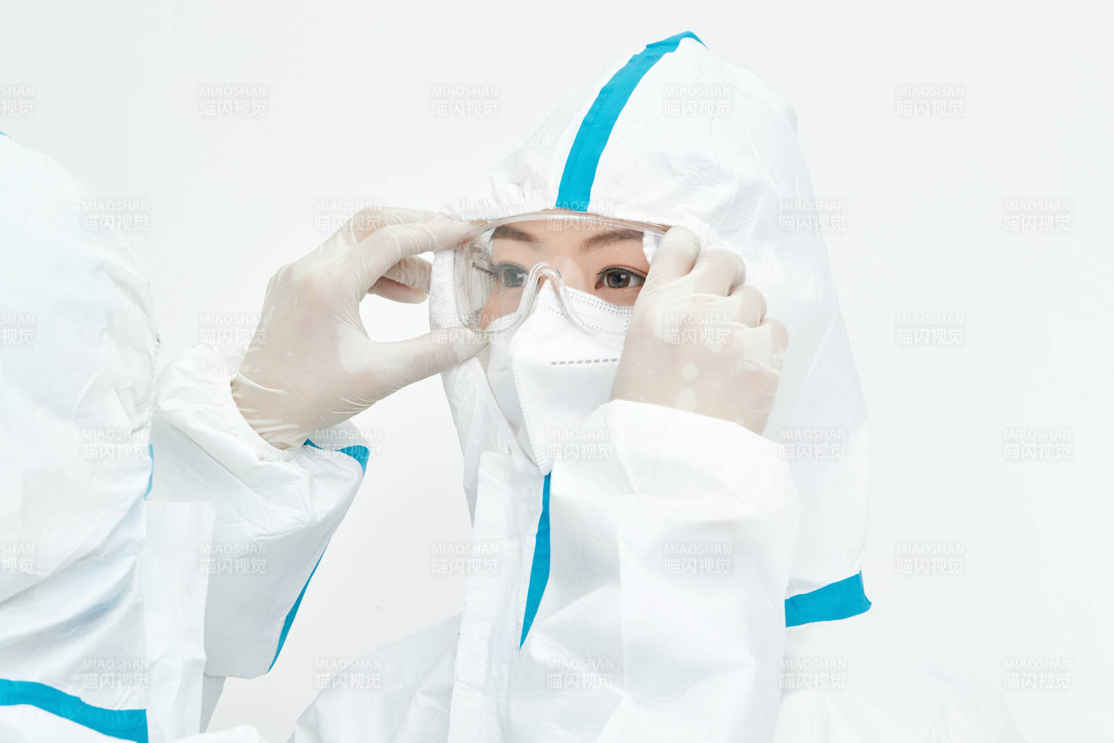 穿白色防护服佩戴护目镜口罩的女性医疗人员图片