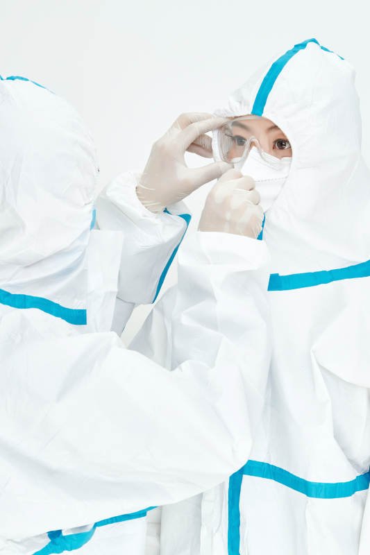 穿白色防护服佩戴护目镜口罩的女性医疗人员图片
