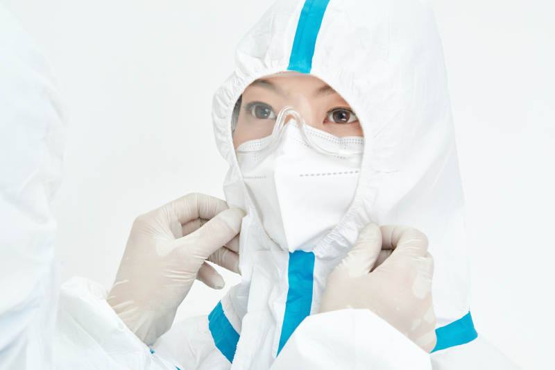 穿白色防护服佩戴护目镜口罩的女性医疗人员图片