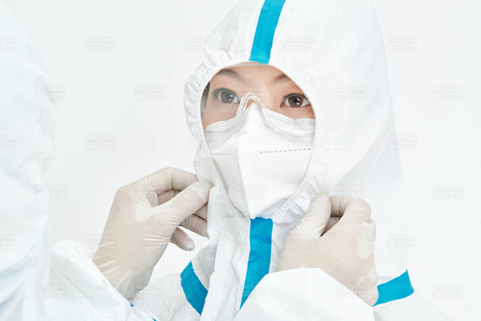 穿白色防护服佩戴护目镜口罩的女性医疗人员图片