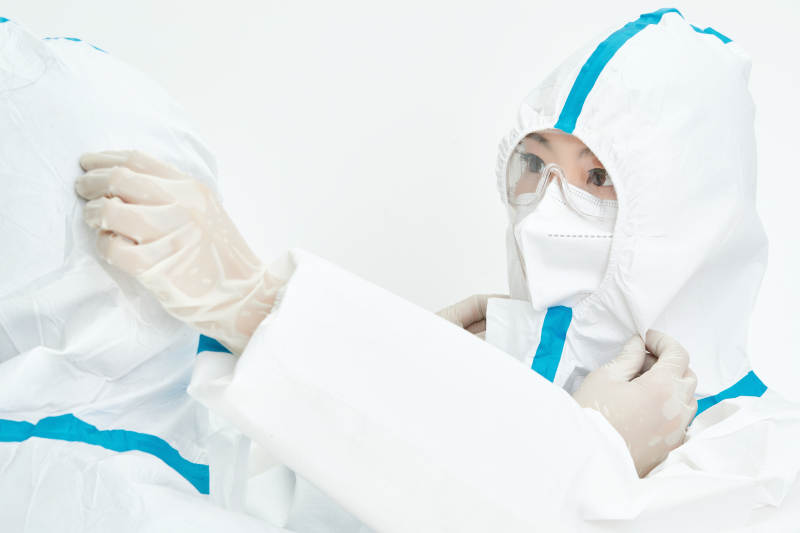 穿白色防护服佩戴护目镜口罩的女性医疗人员图片