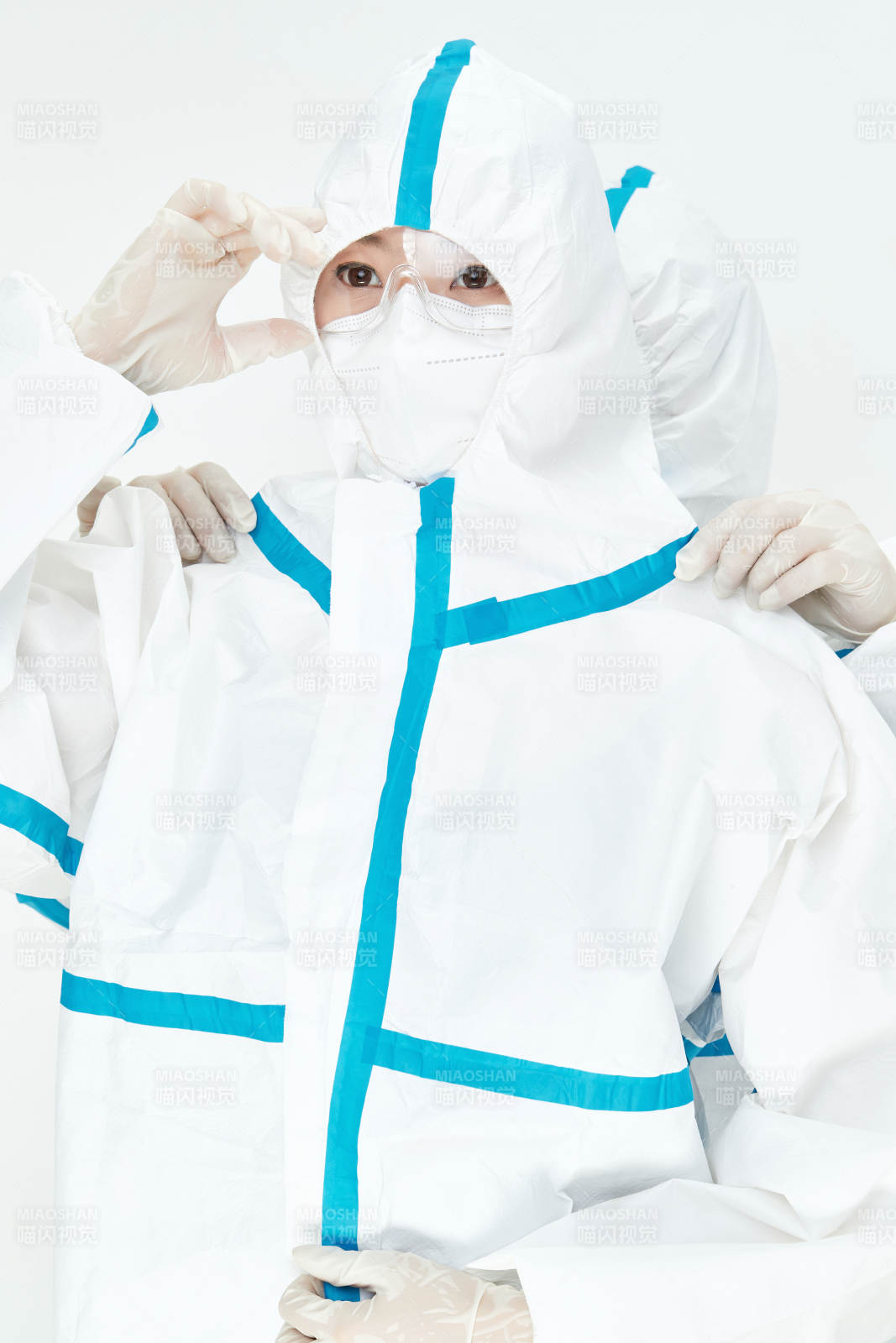 穿白色防护服佩戴护目镜口罩的女性医疗人员图片