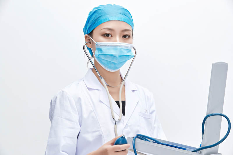 白色背景下手持血压计的门诊医生图片