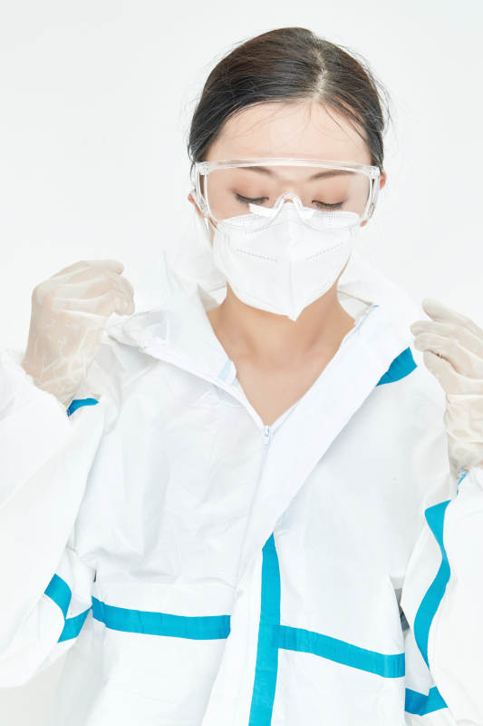 穿白色防护服佩戴护目镜口罩的女性医疗人员图片