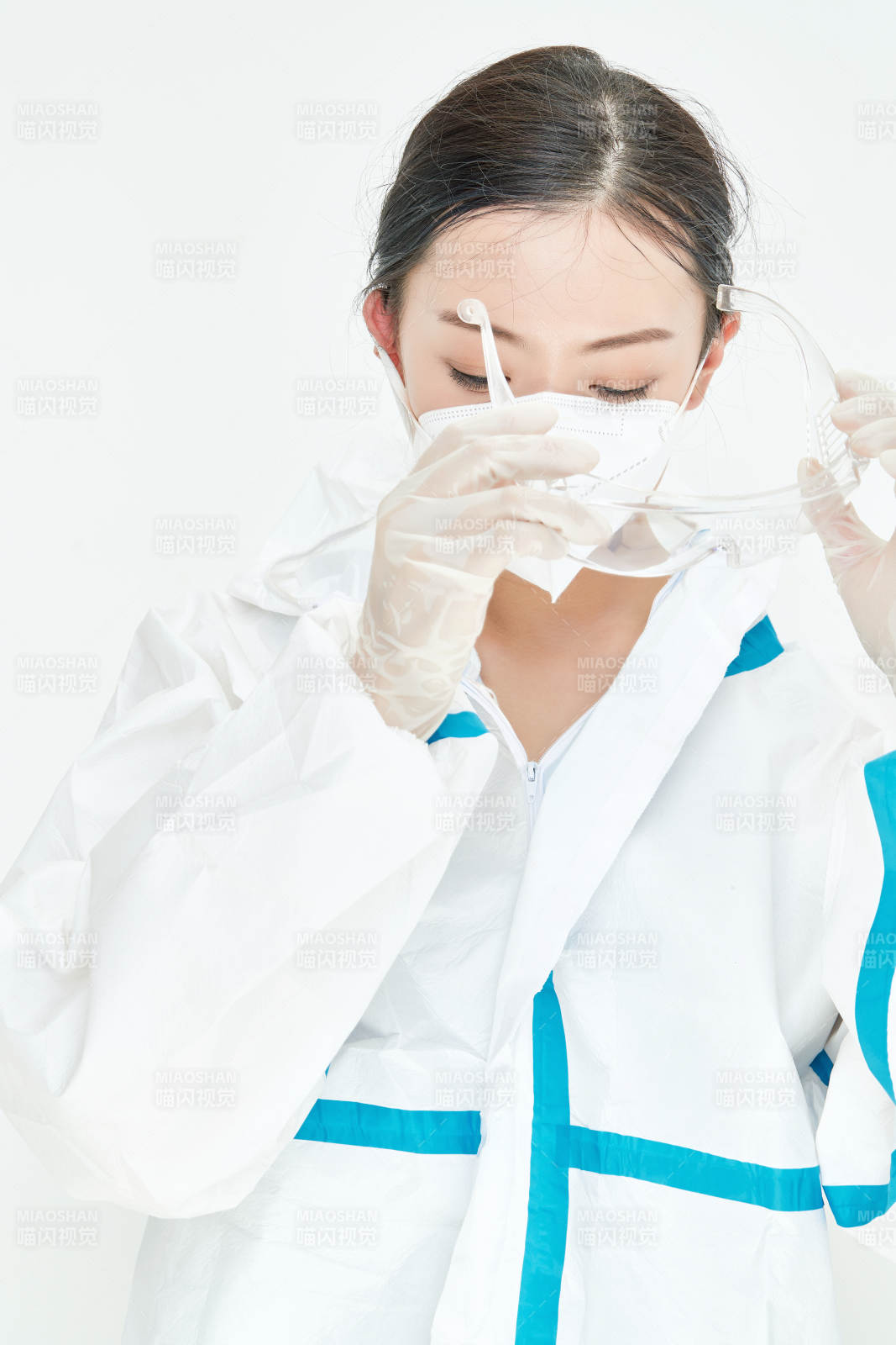 穿白色防护服佩戴护目镜口罩的女性医疗人员图片
