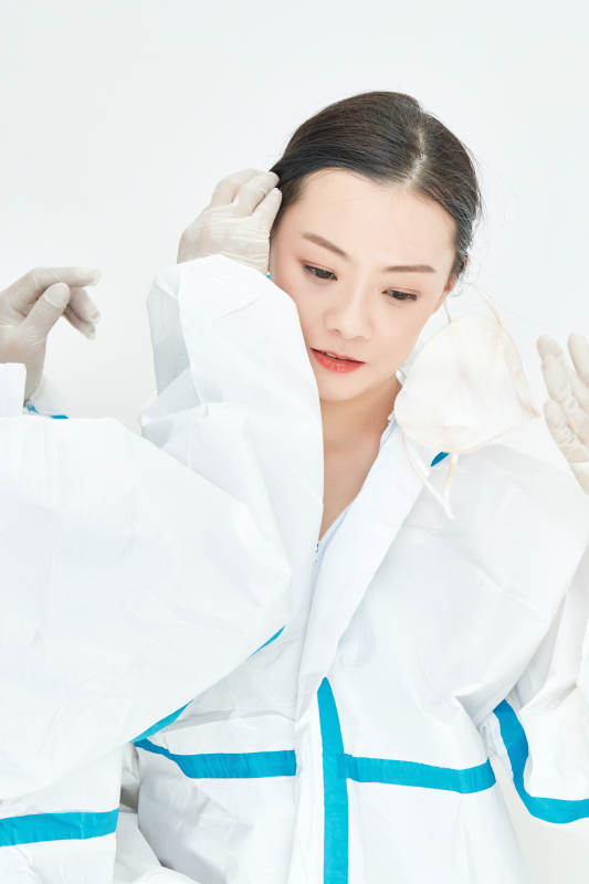 穿白色防护服佩戴护目镜口罩的女性医疗人员图片