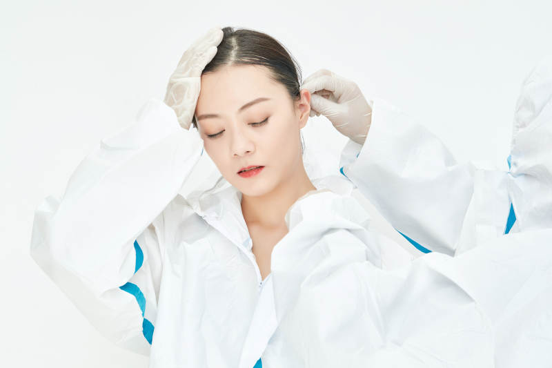 穿白色防护服佩戴护目镜口罩的女性医疗人员图片