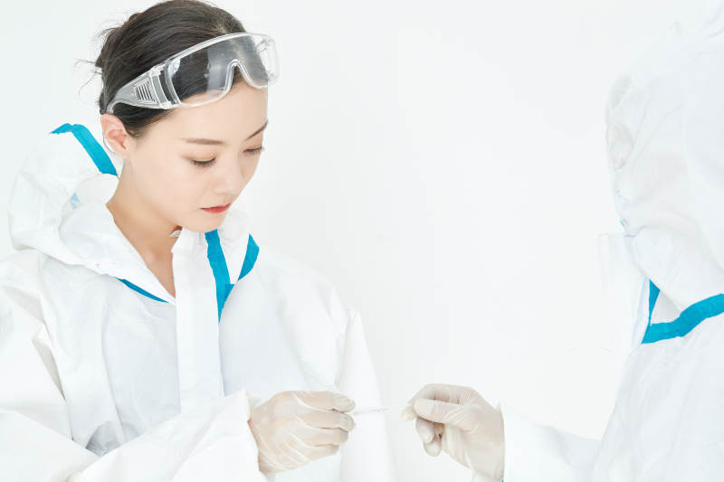 穿白色防护服佩戴护目镜口罩的女性医疗人员图片