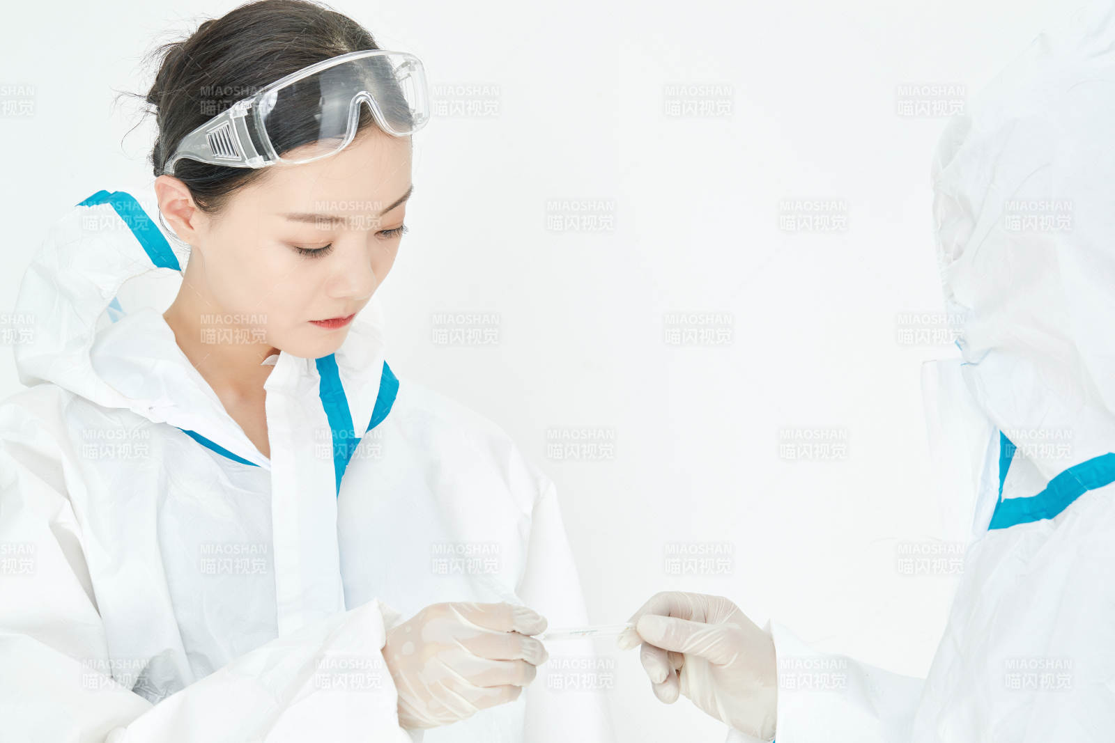 穿白色防护服佩戴护目镜口罩的女性医疗人员图片