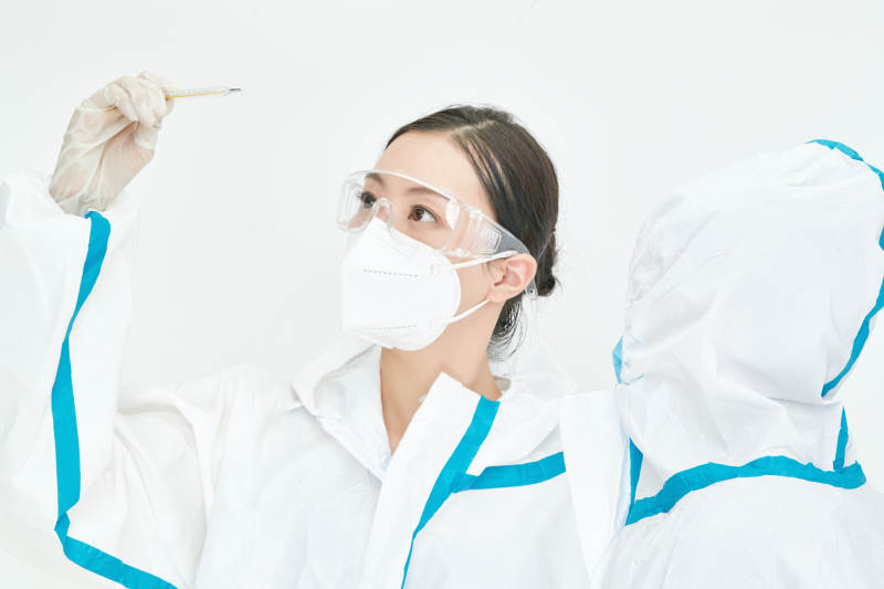 穿白色防护服佩戴护目镜口罩的女性医疗人员图片