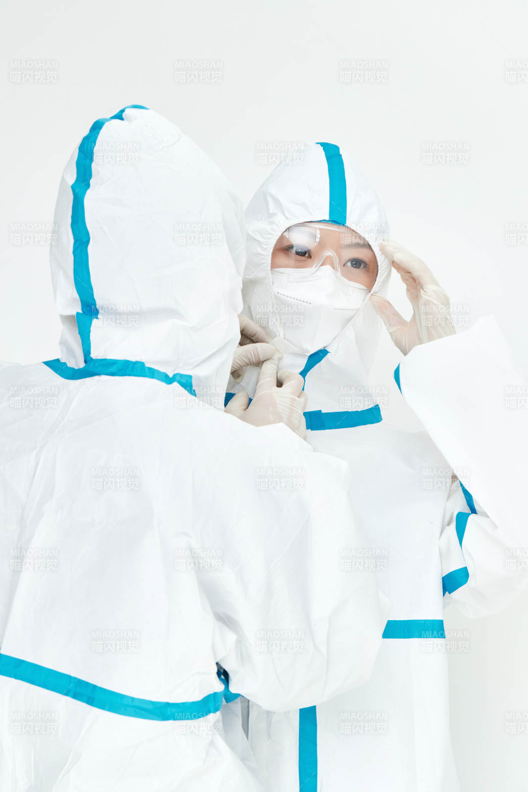 穿白色防护服佩戴护目镜口罩的女性医疗人员图片