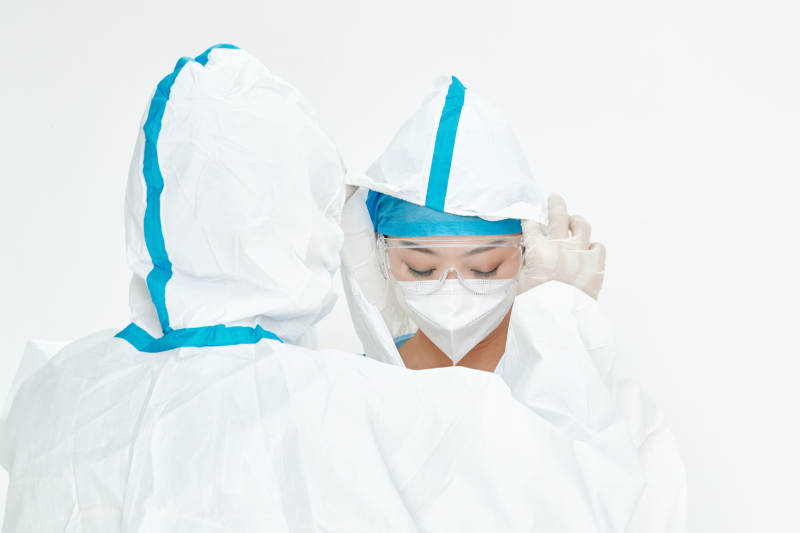 穿白色防护服佩戴护目镜口罩的女性医疗人员图片