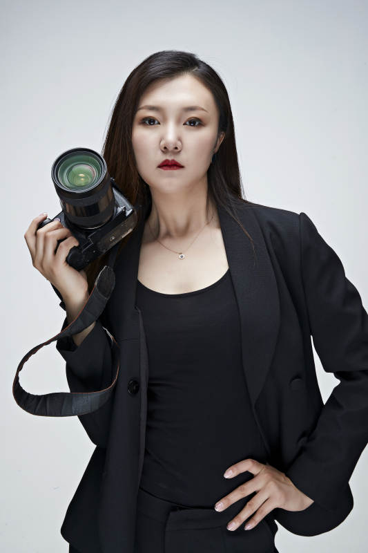 棚拍白色背景亚洲青年女性摄影师图片