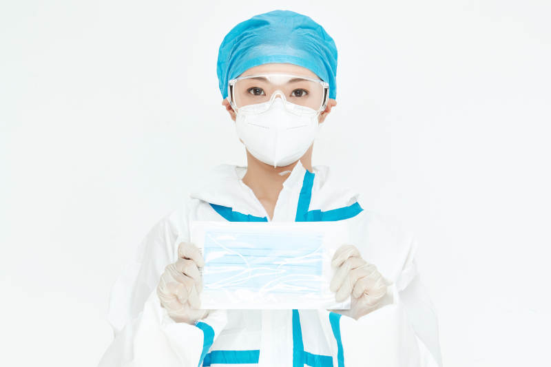 穿白色防护服佩戴护目镜口罩的女性医疗人员图片