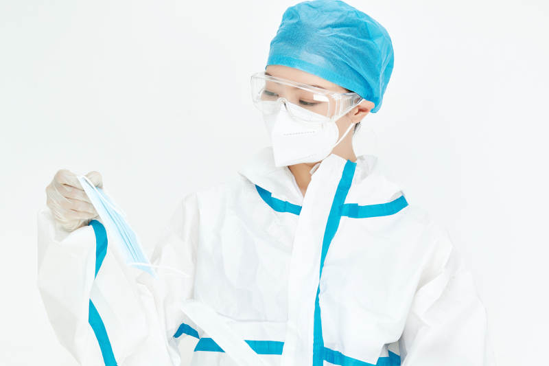 穿白色防护服佩戴护目镜口罩的女性医疗人员图片